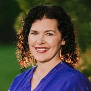 Dr. Michele Broadhurst smiling in blue scrubs, outdoors